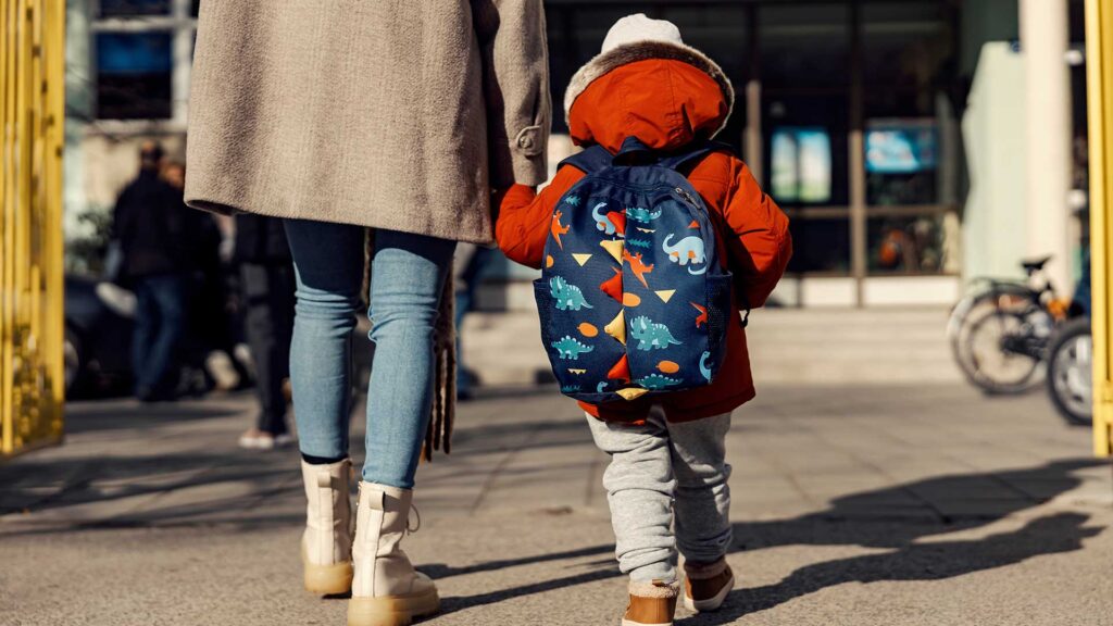 A mother and child walking towards a school