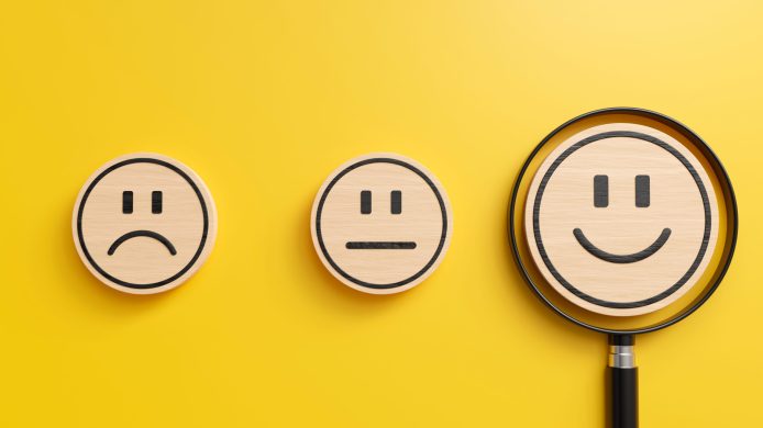 smile emoji icon in magnifying glass on yellow background, opinion surveys and customer satisfaction assessments concept, 3d render