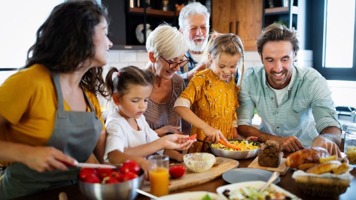 Cheerful happy family spending good time together while cooking in kitchen