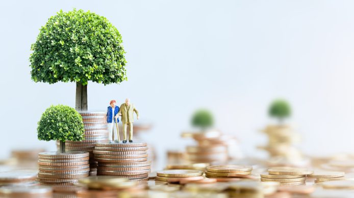 Miniature people: Elderly people sitting on coins stack. social security income and pensions. Money saving and Investment. Time counting down for retirement concept.